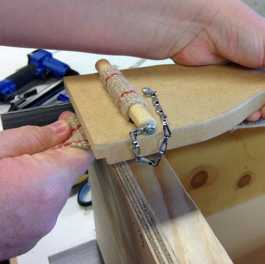 Using a webbing stretcher to install jute webbing
