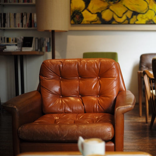 Old mid century brown leather armchair with buttons