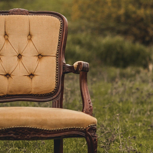 Dining chair with wooden arms, diamond tufting and decorative chair nails
